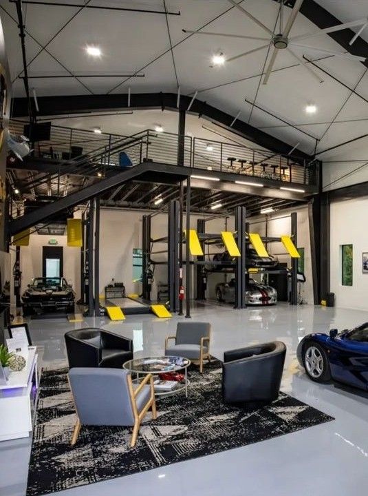 Garage interior with vehicle lifts and cars raised for servicing