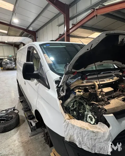 The same Transit Custom from the side, front panel off and the engine open to work on